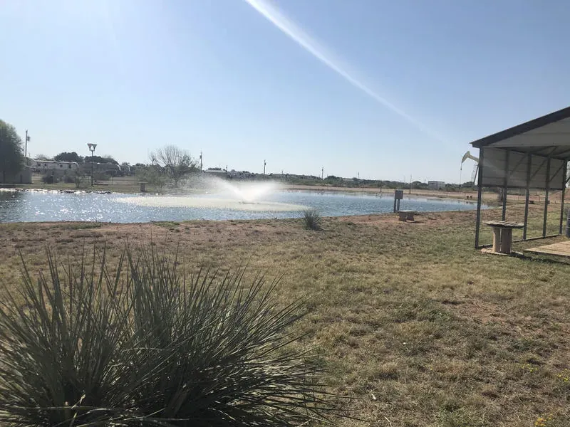 Pond with lit fountain at Mesquite Oasis Lodge & RV Park in Odessa, Texas